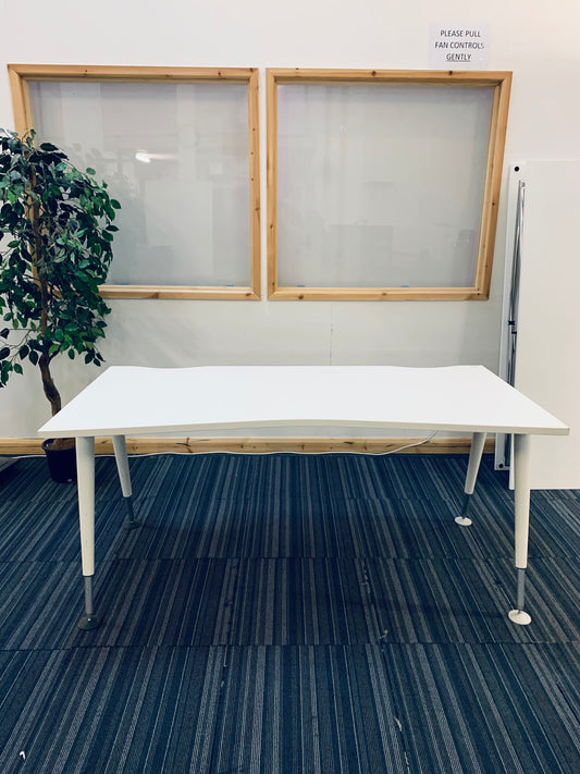 white office desk on carpet with green plant behind