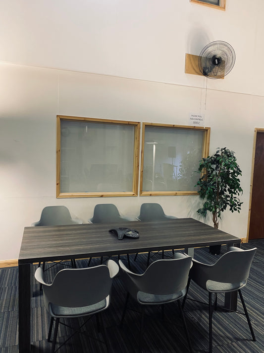 Dark grey office meeting table with six grey chairs around it and mounted table