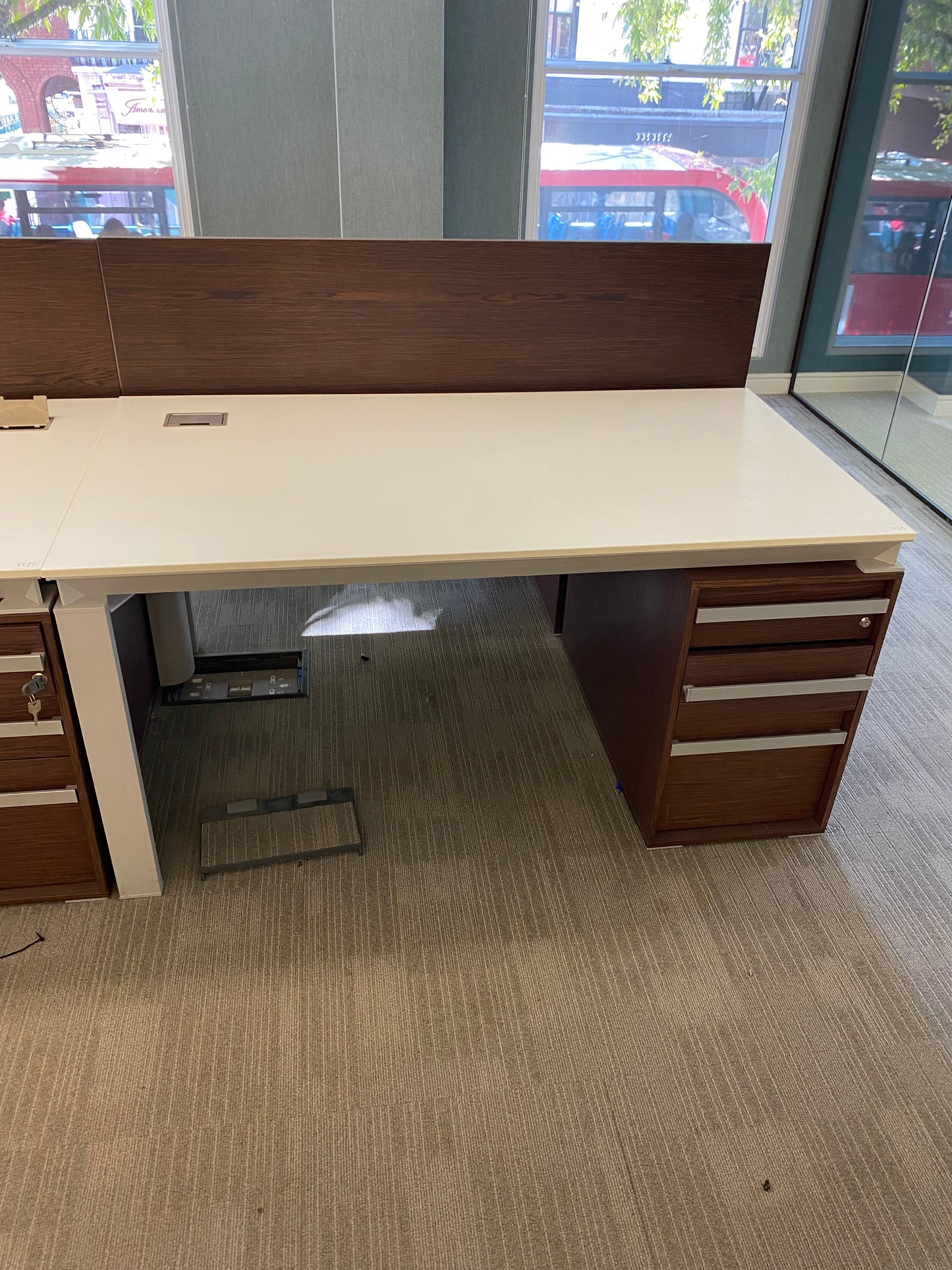 White office table with walnut divider and storagein office with large windows