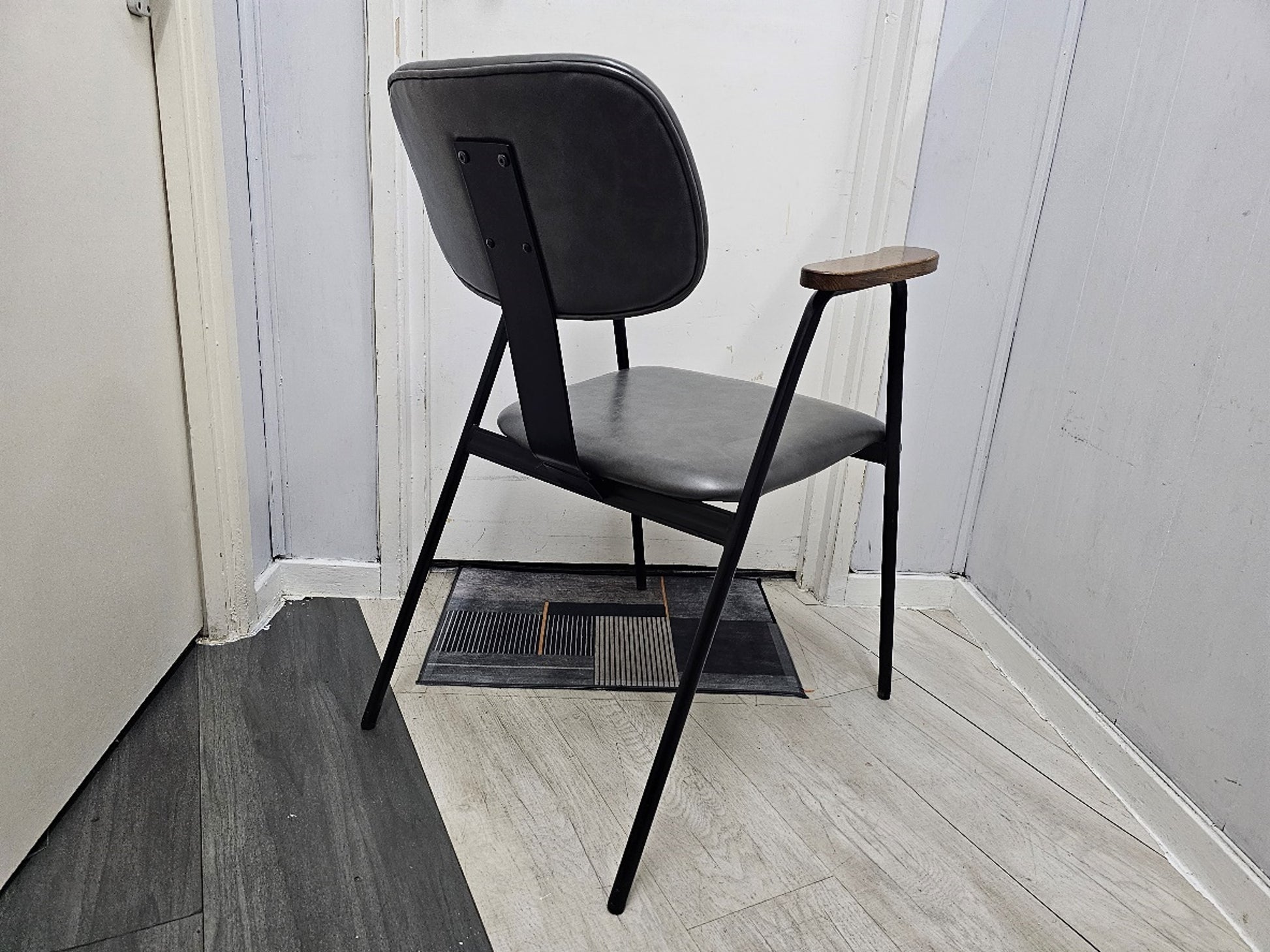 Back of Grey leather waiting room chair, brown armpads