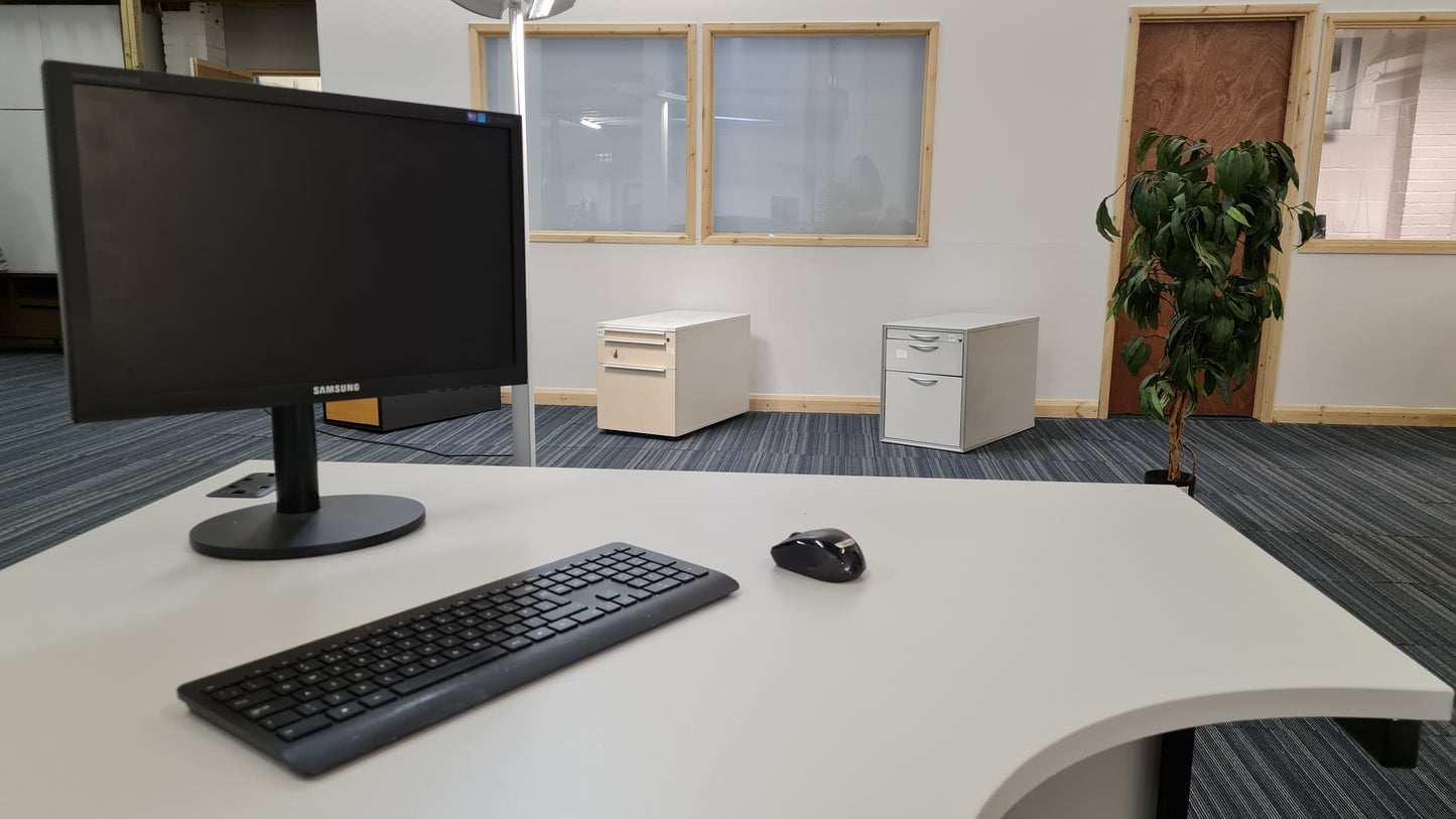 Samsung SyncMaster B1940W monitor on corner table in front of 3 office drawers