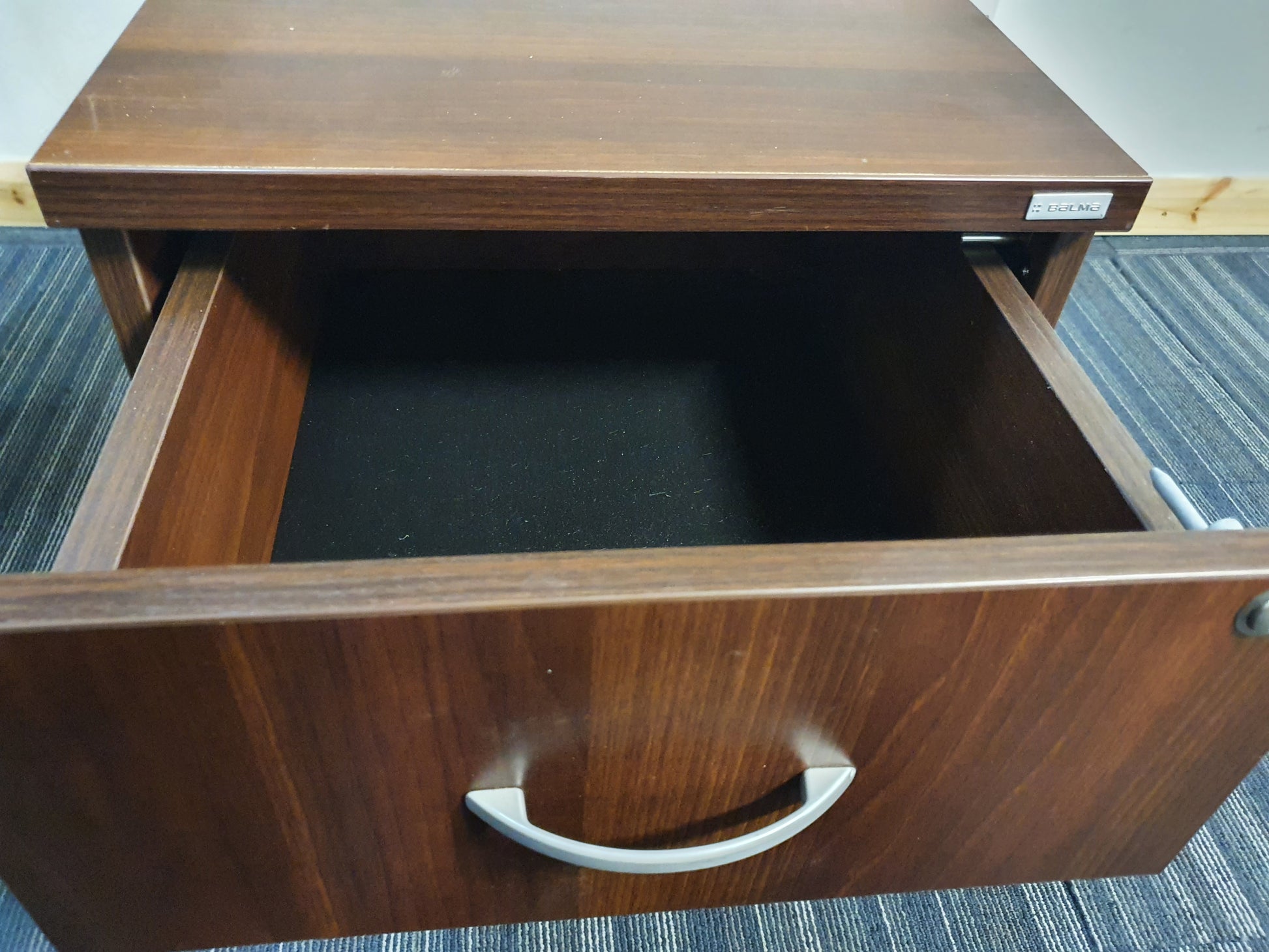 Open top drawer of brown filing cabinet