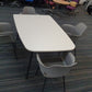 White office meeting table and four grey chairs in large room