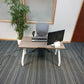 Tall green plant, grey desk chair at small office table with monitor and keyboard