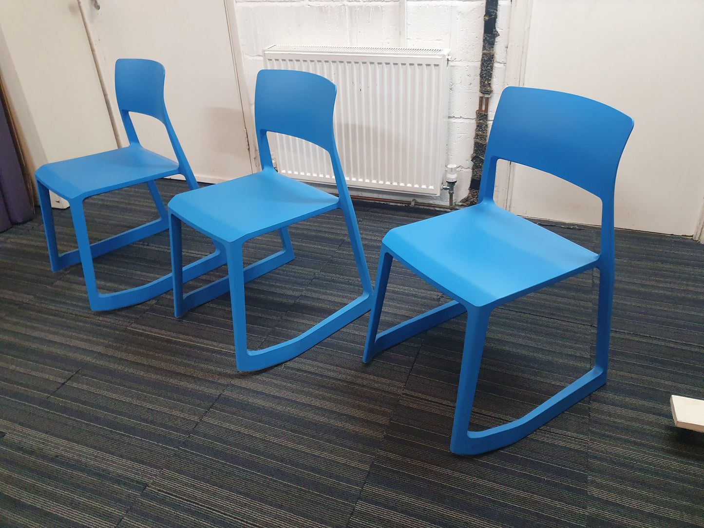 Azure blue reception chairs in front of radiator