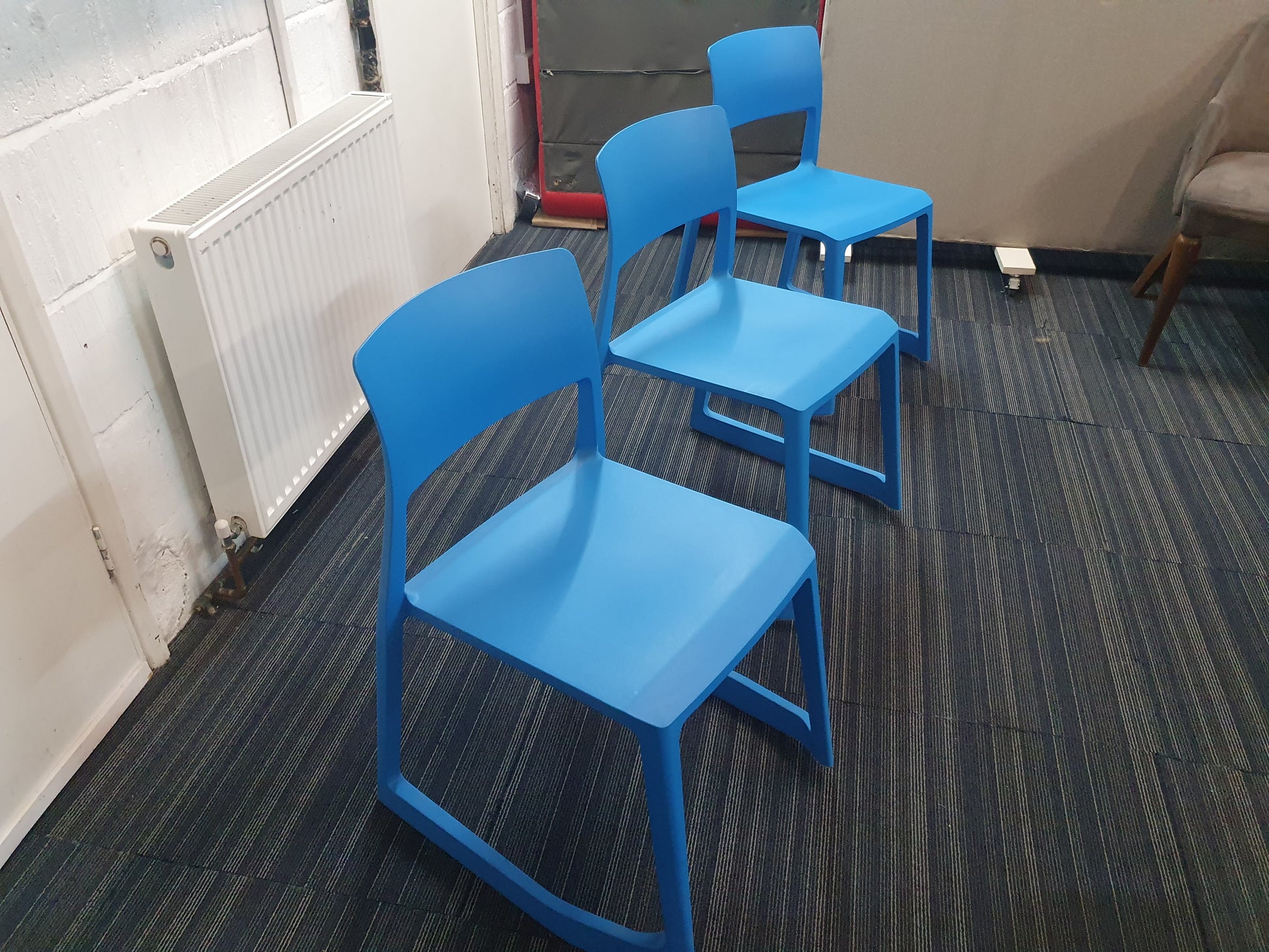 Three blue waiting area chairs in a row
