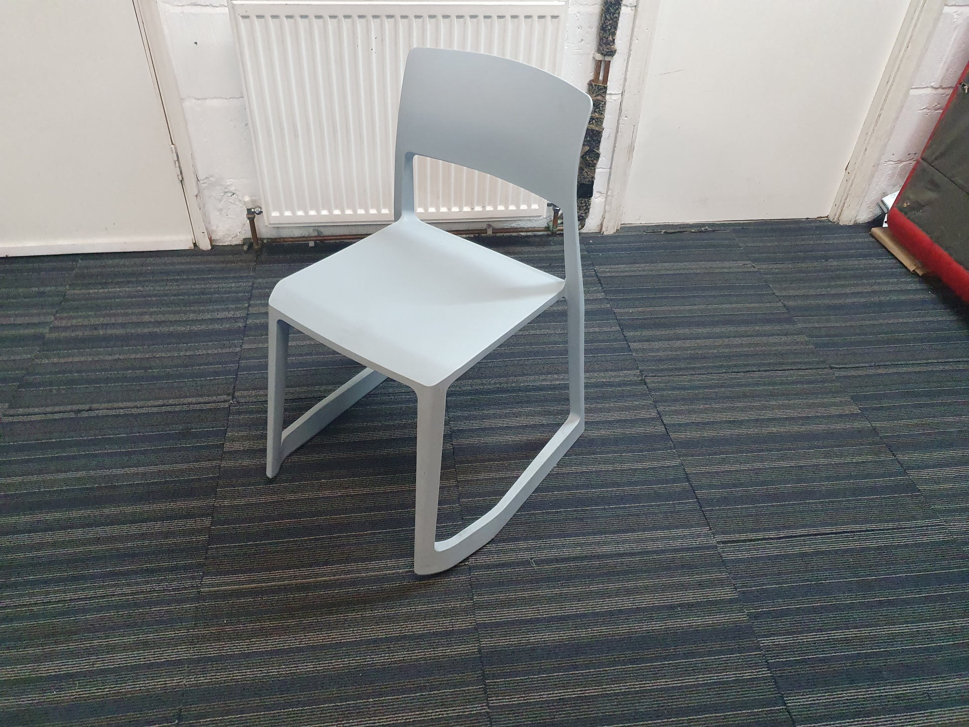 Light blue cantilever chair on blue carpet