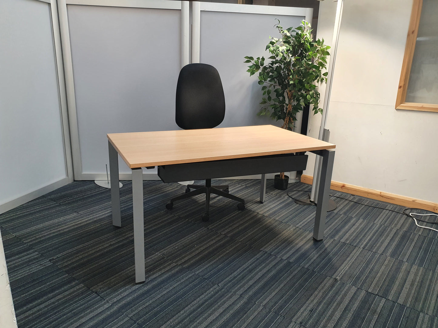 Workstation set up in brown table in front of black task chair