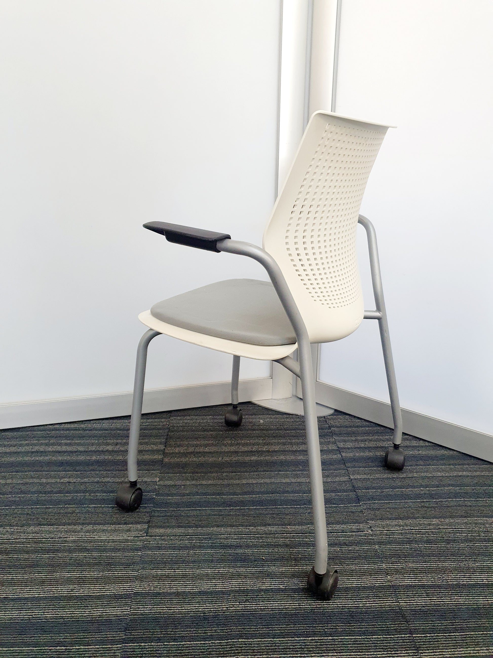 Side of white office chair on wheels