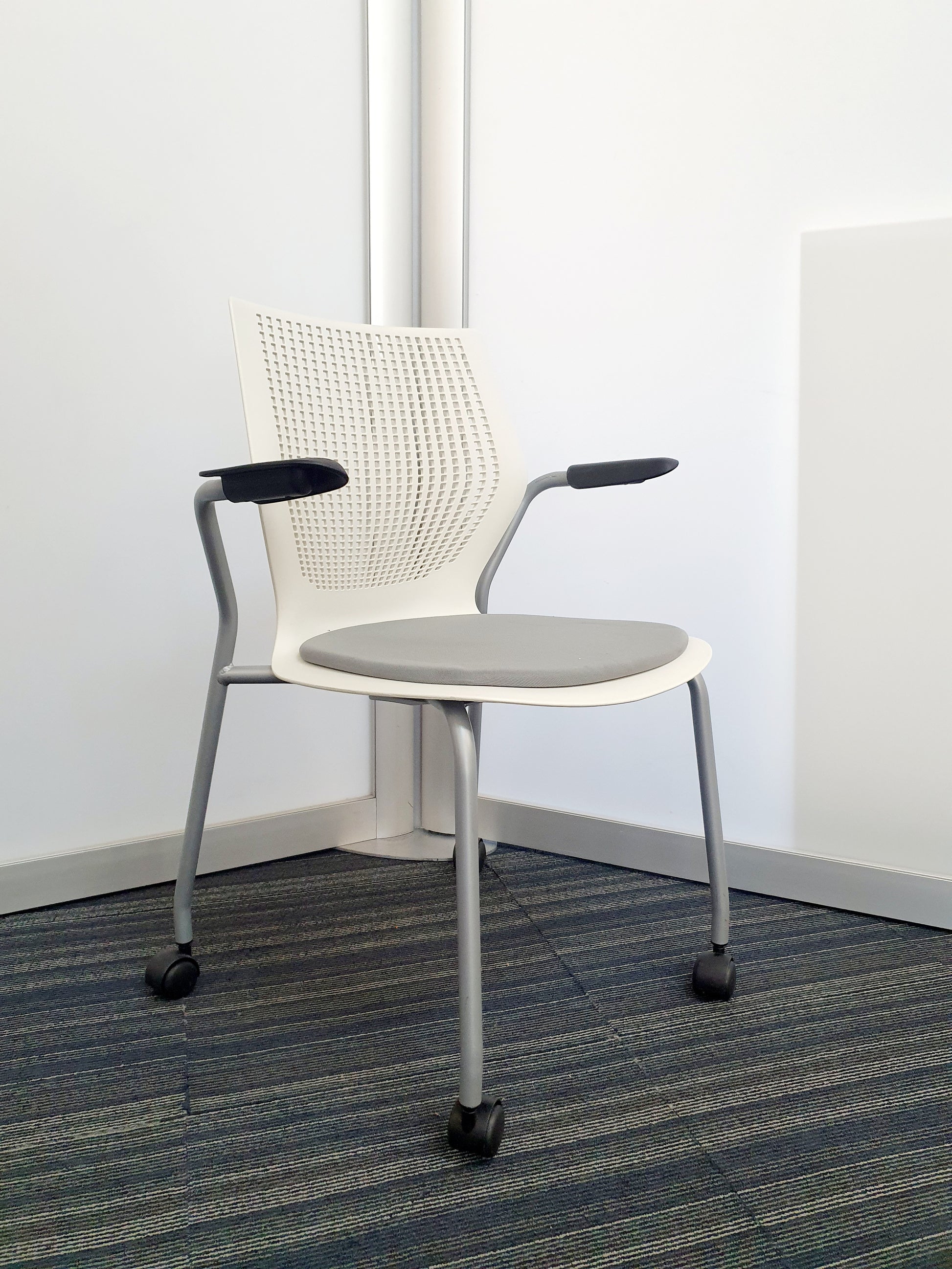 Stackable white chair by Knoll on wheels