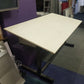 Tilting white drawing table in front of purple sofa