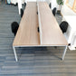 six black chairs tucked under walnut office tables