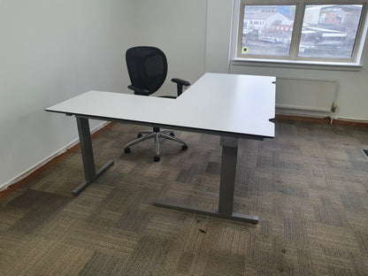 L shaped Spacious office table and black chair in office corner 