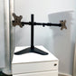 a black articulated Freestanding Desktop Monitor stand on white drawers