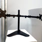Black Dual Screen Articulated Adjustable Monitor Arm on a drawer
