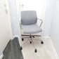 Grey office swivel chair on castors in front of 2 doors