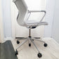 Mesh chair in grey and white in front of white door