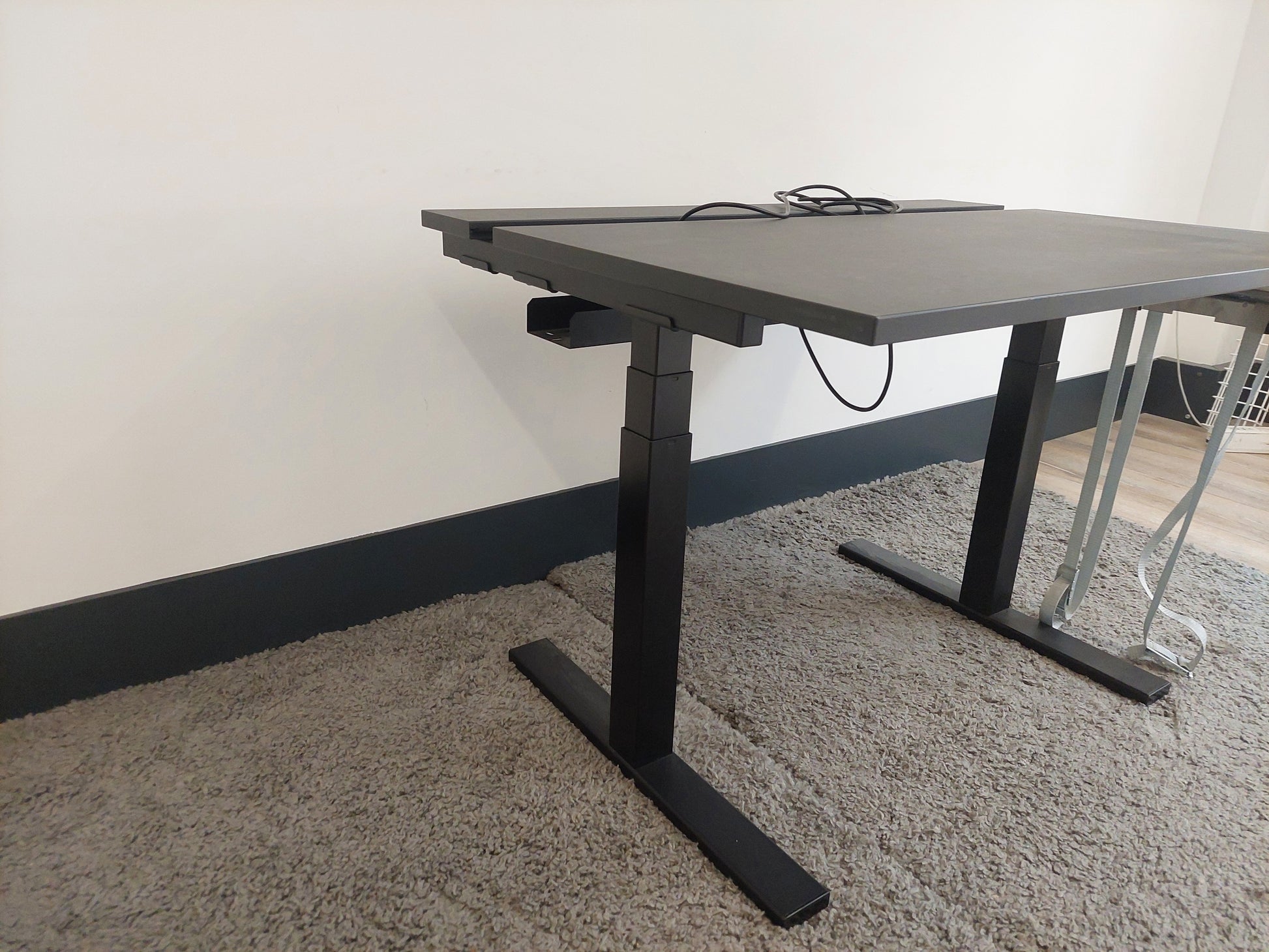 Black legs of height adjustable office desk