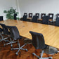 Black swivel desk chairs around Brown Large board room table