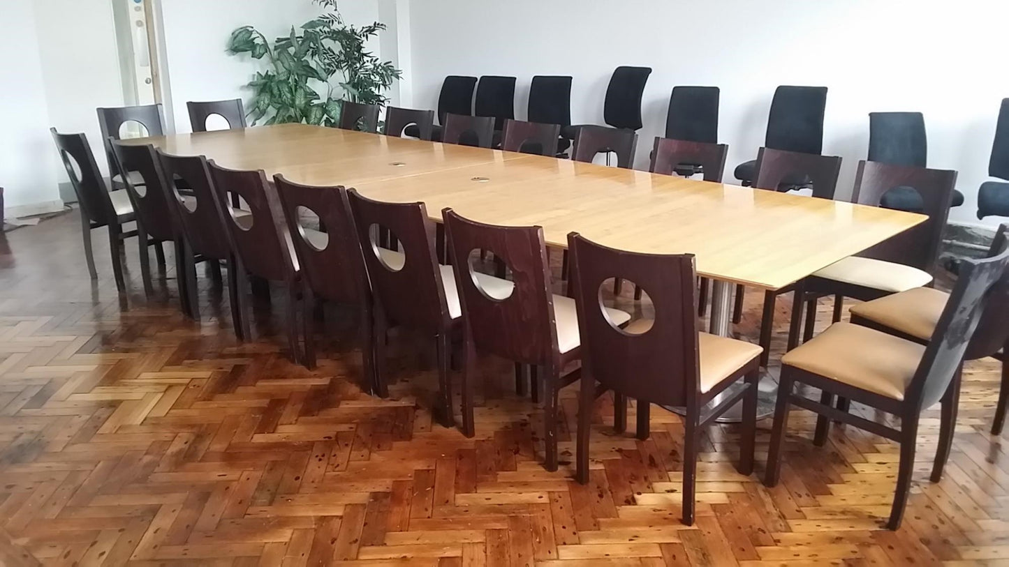 Large conference room table with 20 seats and eight black chairs