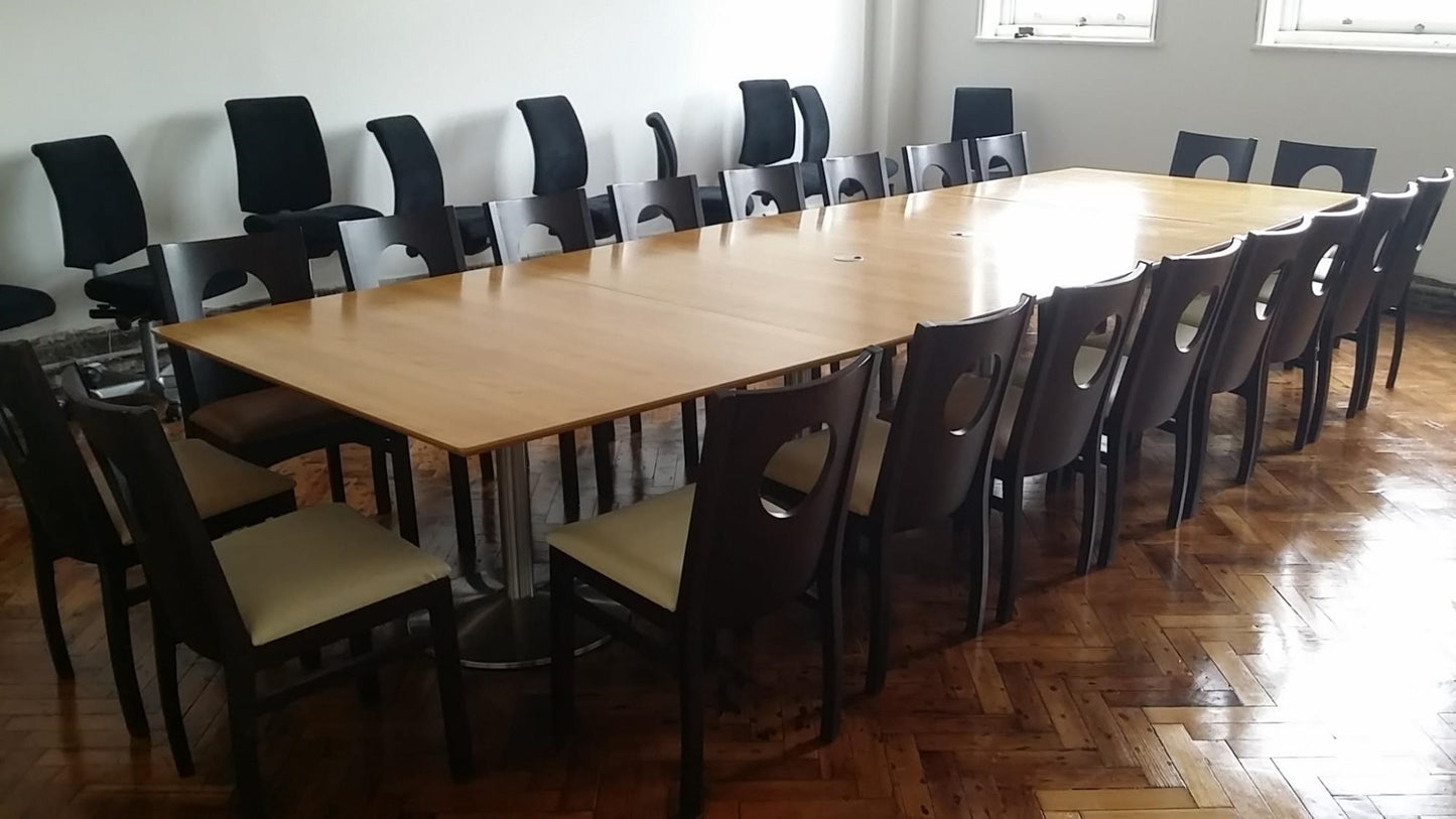 Stick chairs around brown large meeting table