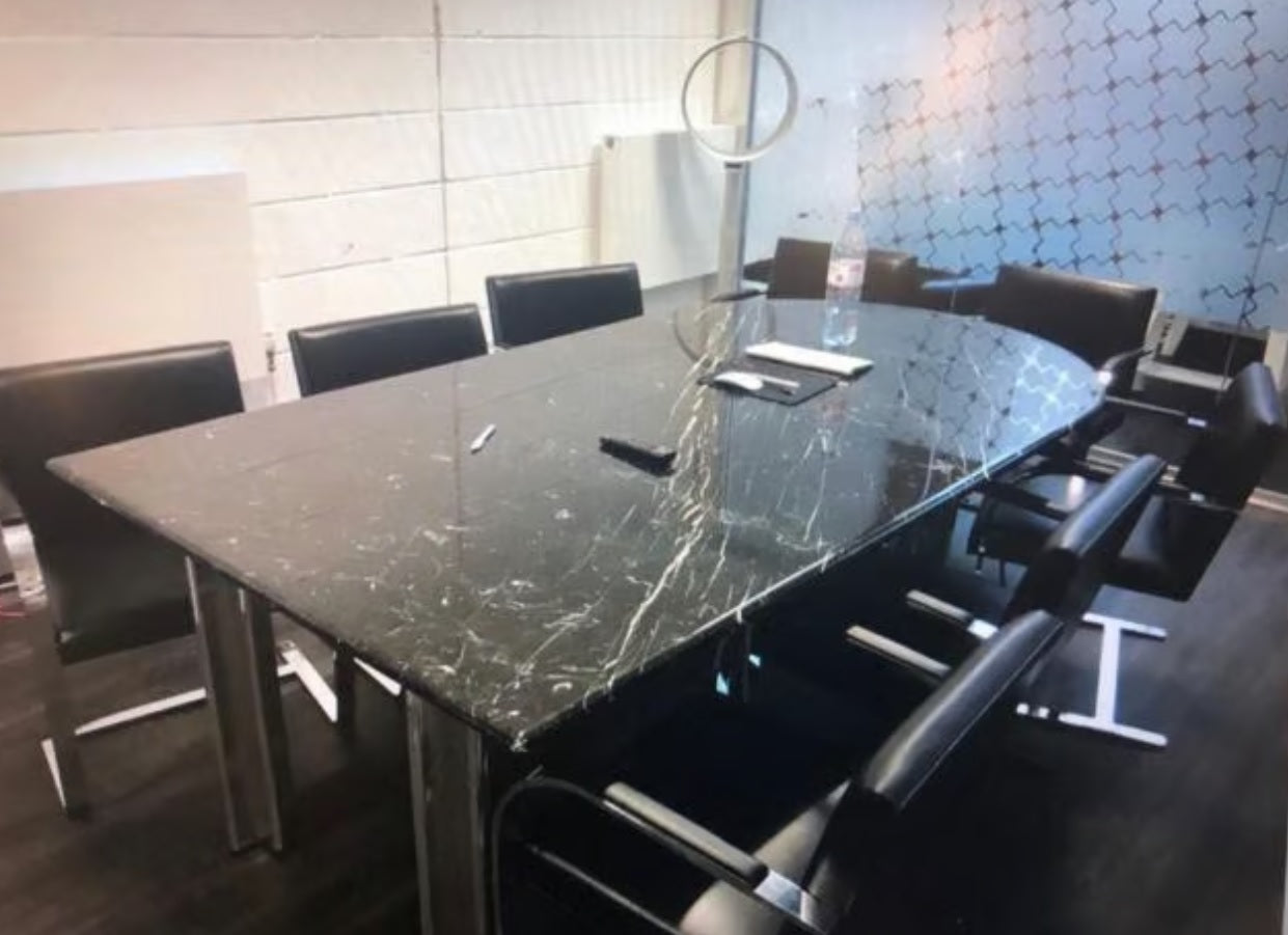 A boardroom setting featuring a large rectangular Nero Marquina marble conference boardroom meeting table 