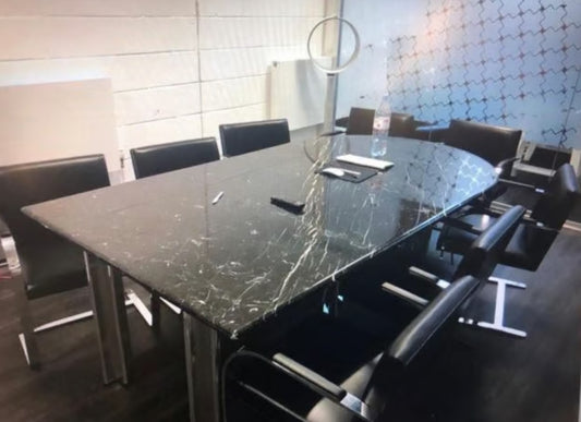 A boardroom setting featuring a large rectangular Nero Marquina marble conference boardroom meeting table 