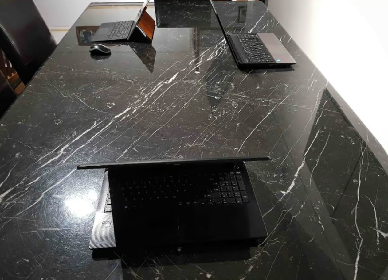 A boardroom setting featuring a large rectangular Nero Marquina marble conference boardroom meeting table 
