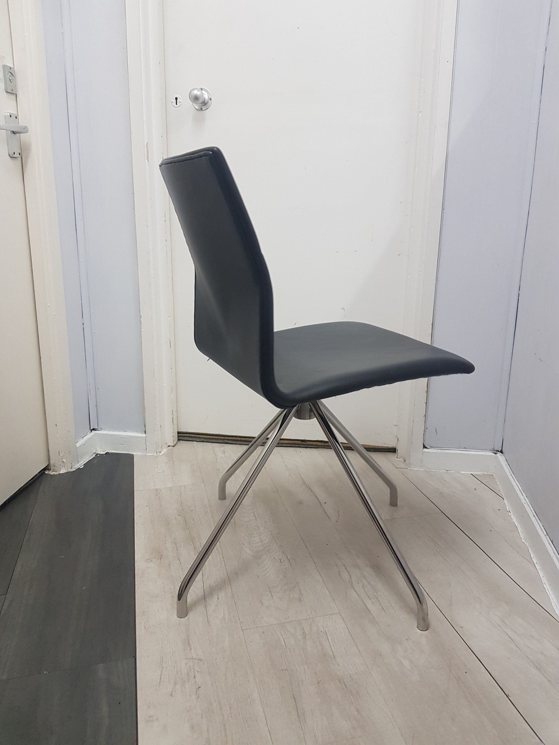 Side of black meeting chair in front of doors 