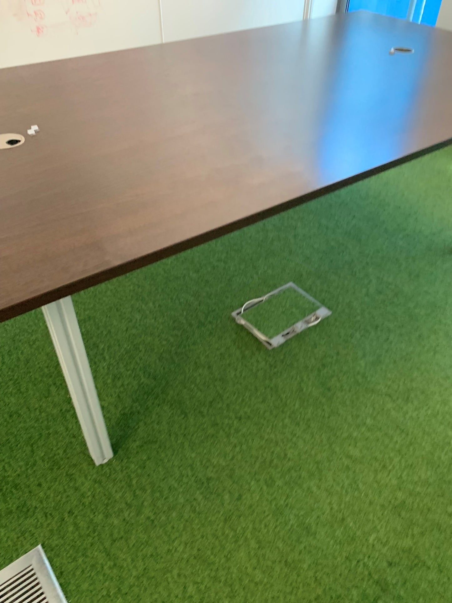 Dark brown walnut table for boardroom on green carpet