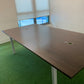 Brown boardroom table in room with large windows