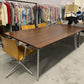 Walnut meeting table by open wardrobe of clothes