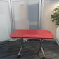 Red table on wheels in front of grey screen