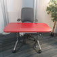 Red small office table with wires and grey chair