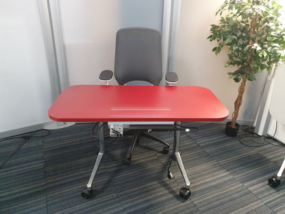 Red small office table with wires and grey chair