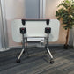 Back of folded office desk on wheels, right, green plant in black pot
