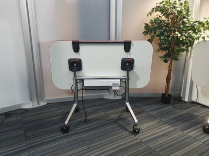 Back of folded office desk on wheels, right, green plant in black pot