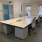 Banck of six office desks in White by office windows