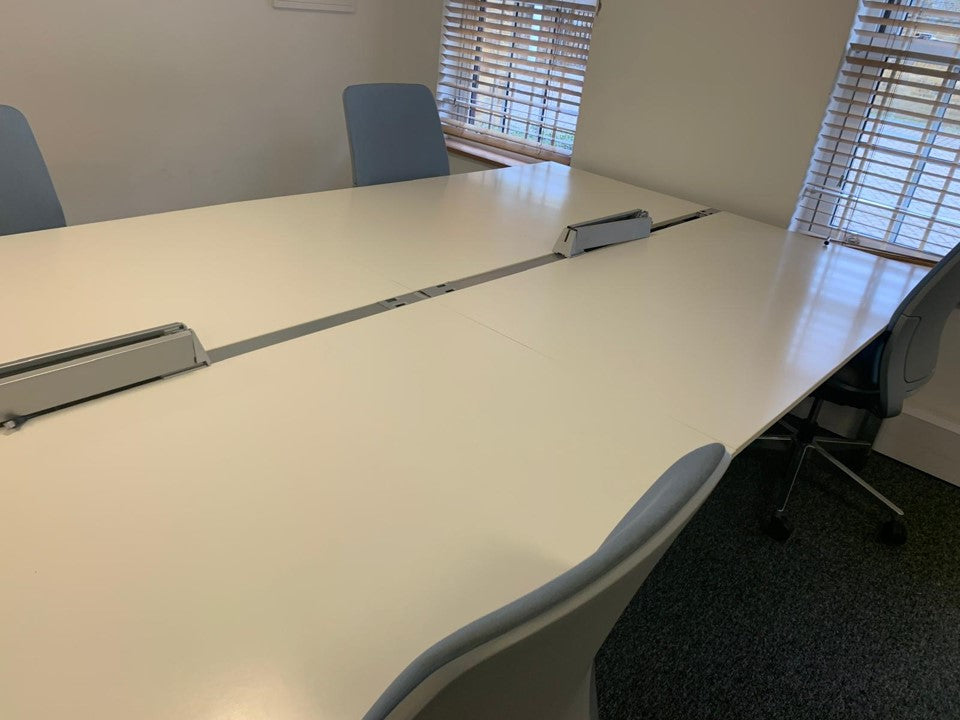 White office table and blue armless desk chairs