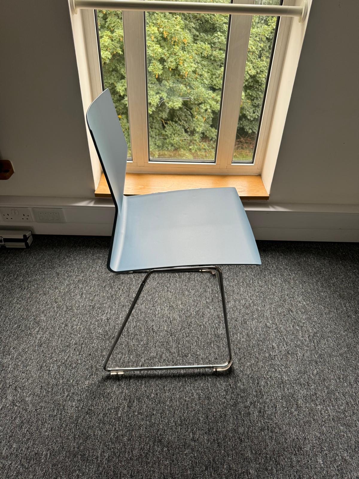 Blue chair on chrome frame by window