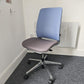 A blue and grey swivel admin chair in front of radiator