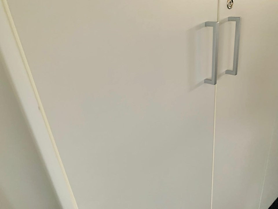 Grey handles on white office cupboard