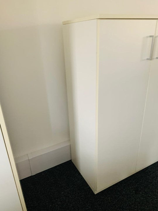 Side of white cupboard on carpet