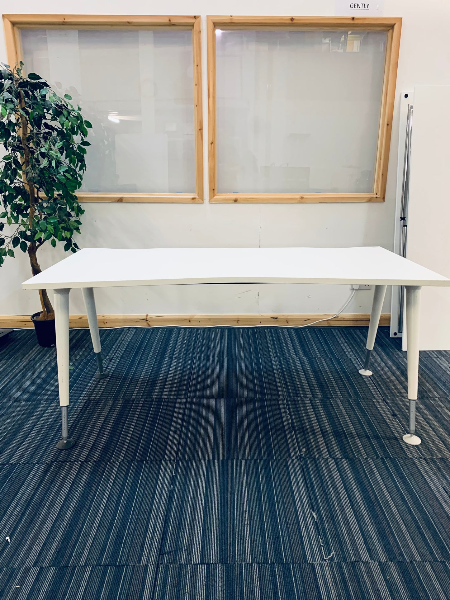 white rectangular office desk in front of double windows