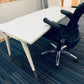 black ergonomic task chair tucked in to a white table