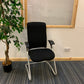 left, green plant, centre Black executive cantilever chair
