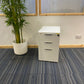 White three drawer small filing cabinet and tall green plant