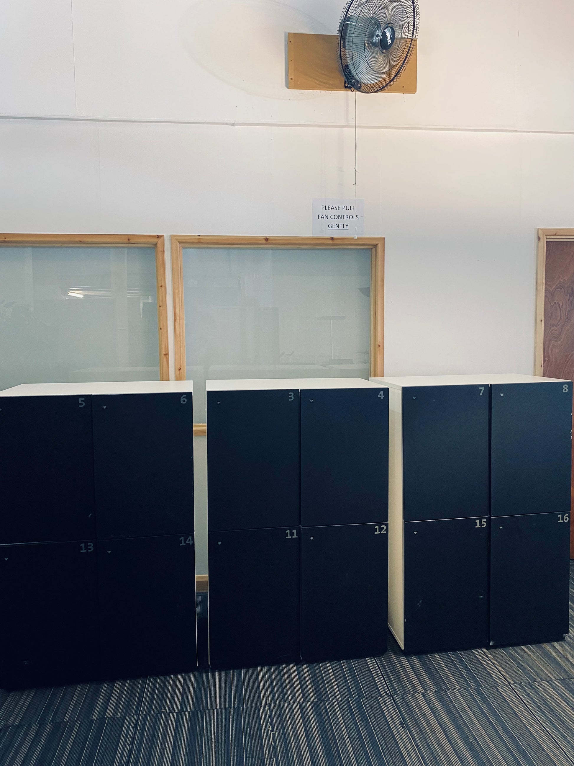 Three lockers under a fan on wall