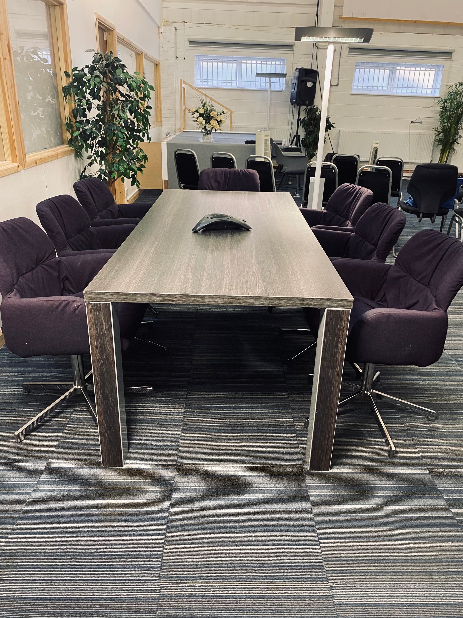 Walnut boardroom table and tall green plants