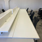 Black chairs and white office bench desks in white